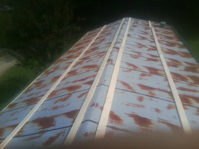 Rusted metal roof panels with new wood purlins before replacement — Storm Damage Roof Repair in Athens by Roofing Brothers